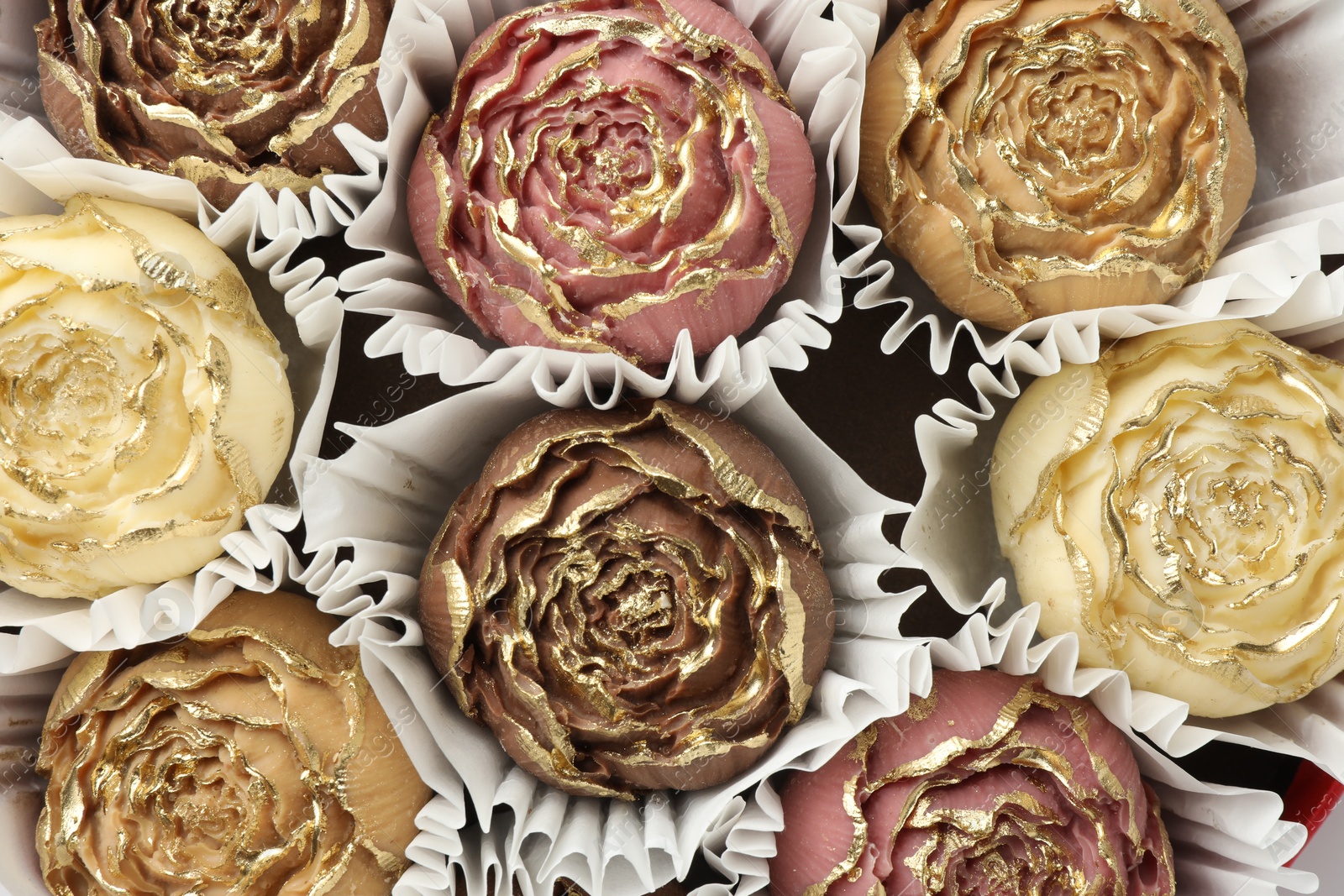 Photo of Flower shaped chocolate bonbons as background, top view