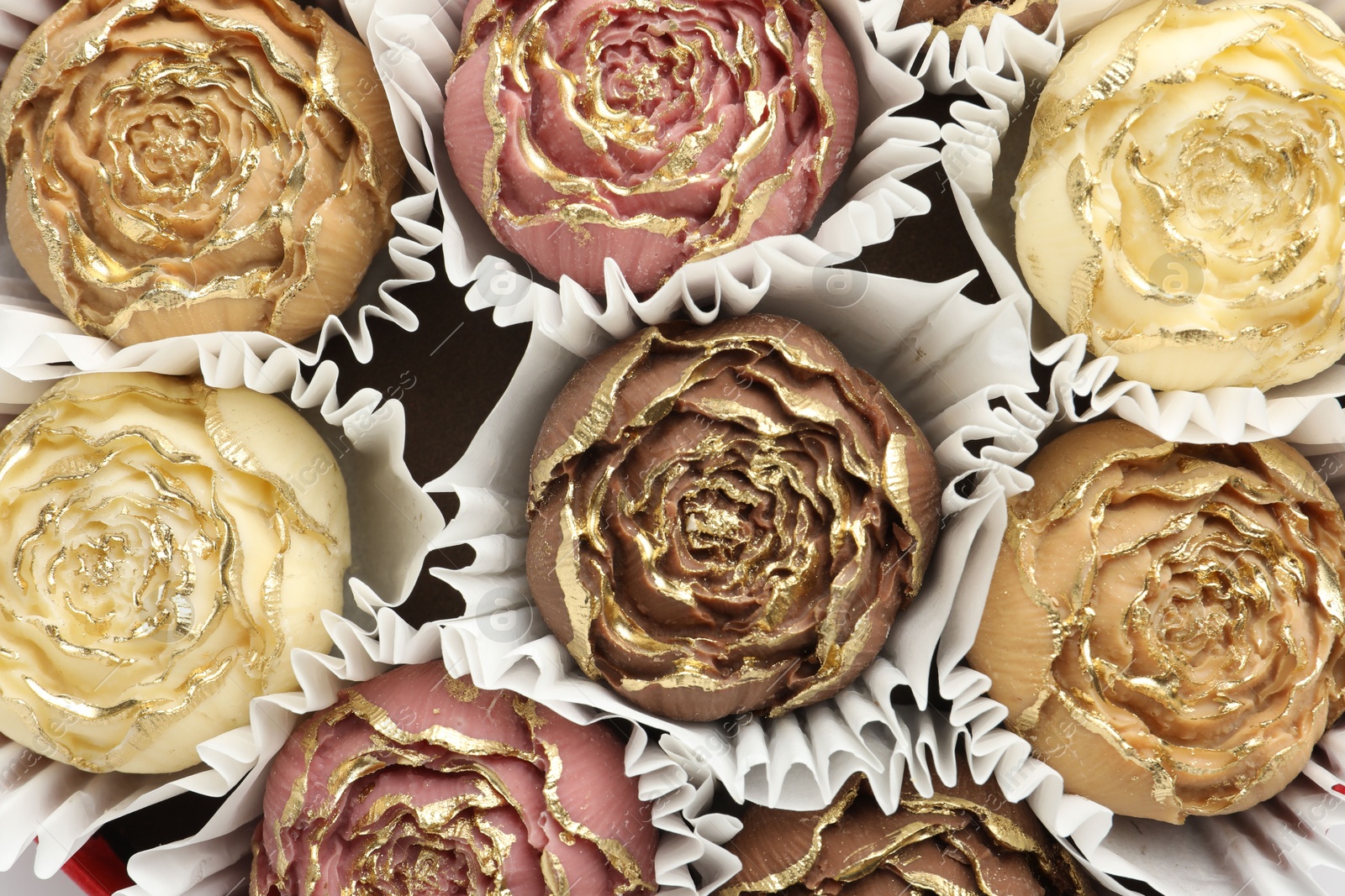 Photo of Flower shaped chocolate bonbons as background, top view