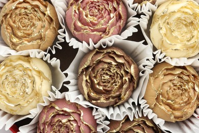 Photo of Flower shaped chocolate bonbons as background, top view