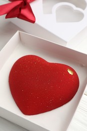 Photo of Heart shaped chocolate in box on table, closeup