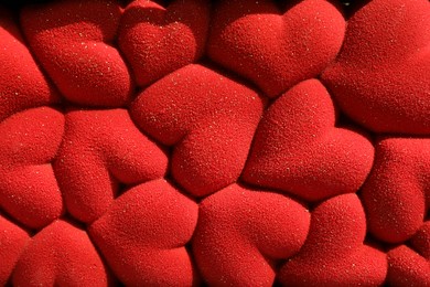 Photo of Chocolate bar decorated with hearts as background, closeup