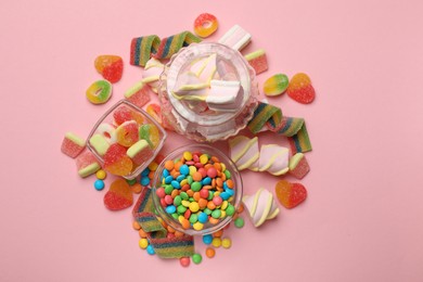 Photo of Many different tasty candies and marshmallows on pink background, flat lay