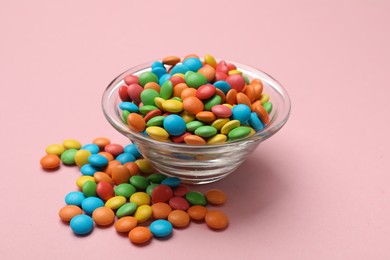 Photo of Tasty candies in bowl on pink background, closeup