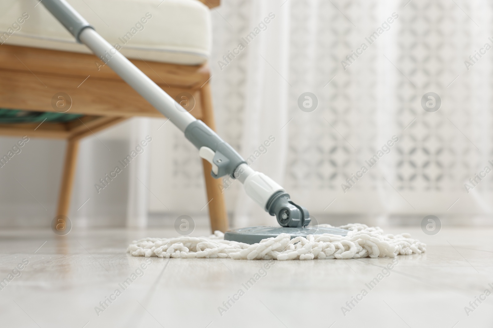 Photo of String mop on floor indoors. Cleaning equipment