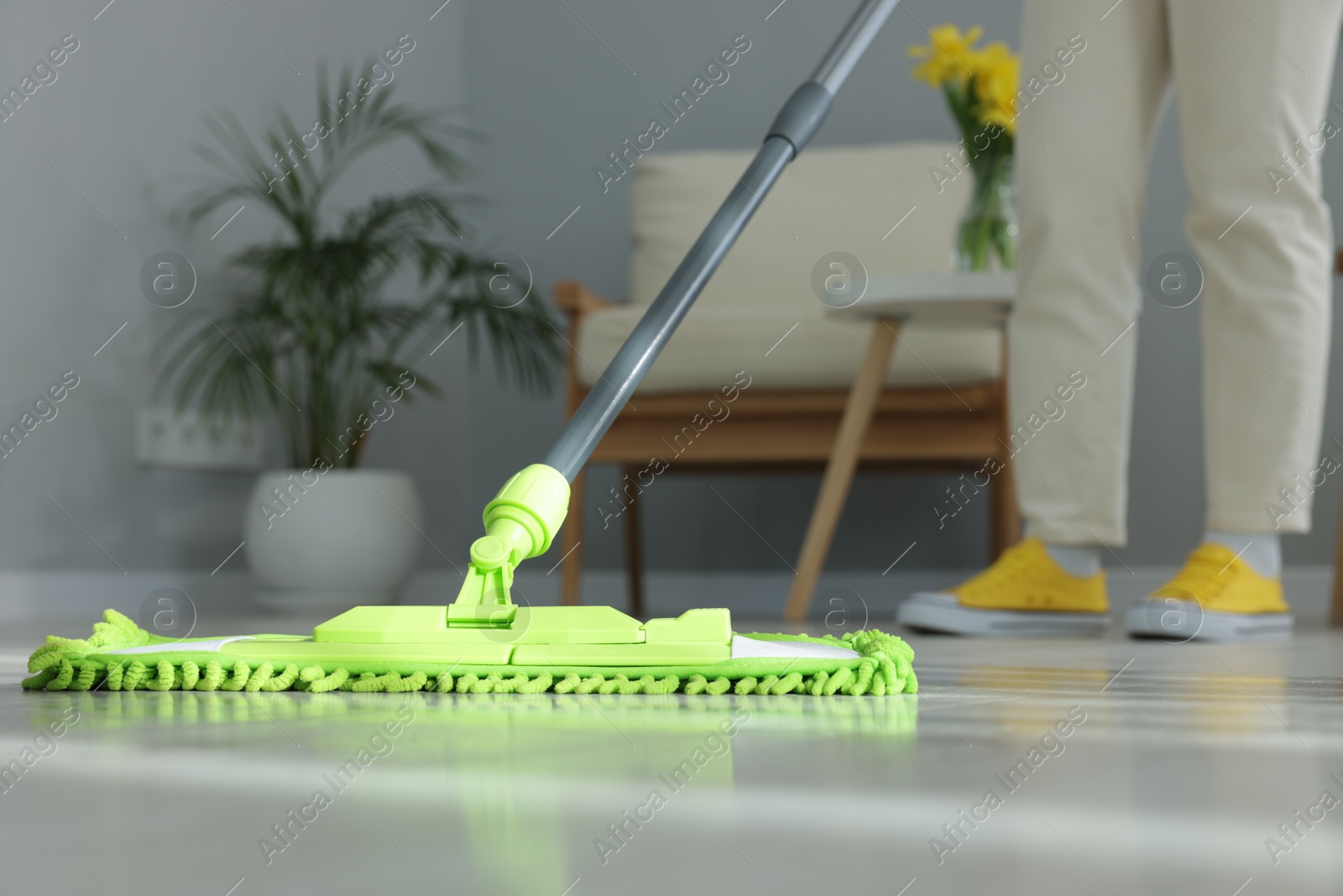 Photo of Woman cleaning floor with microfiber mop indoors, closeup