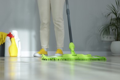 Photo of Woman cleaning floor with microfiber mop indoors, closeup