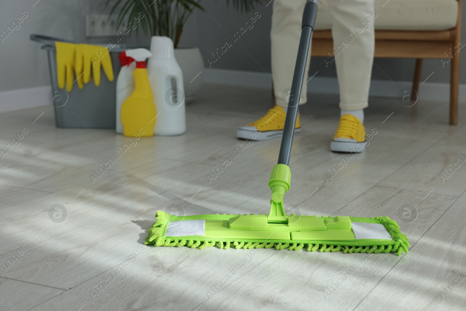 Photo of Woman cleaning floor with microfiber mop indoors, closeup