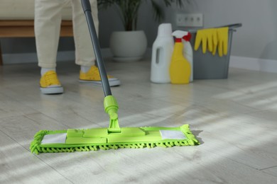 Photo of Woman cleaning floor with microfiber mop indoors, closeup