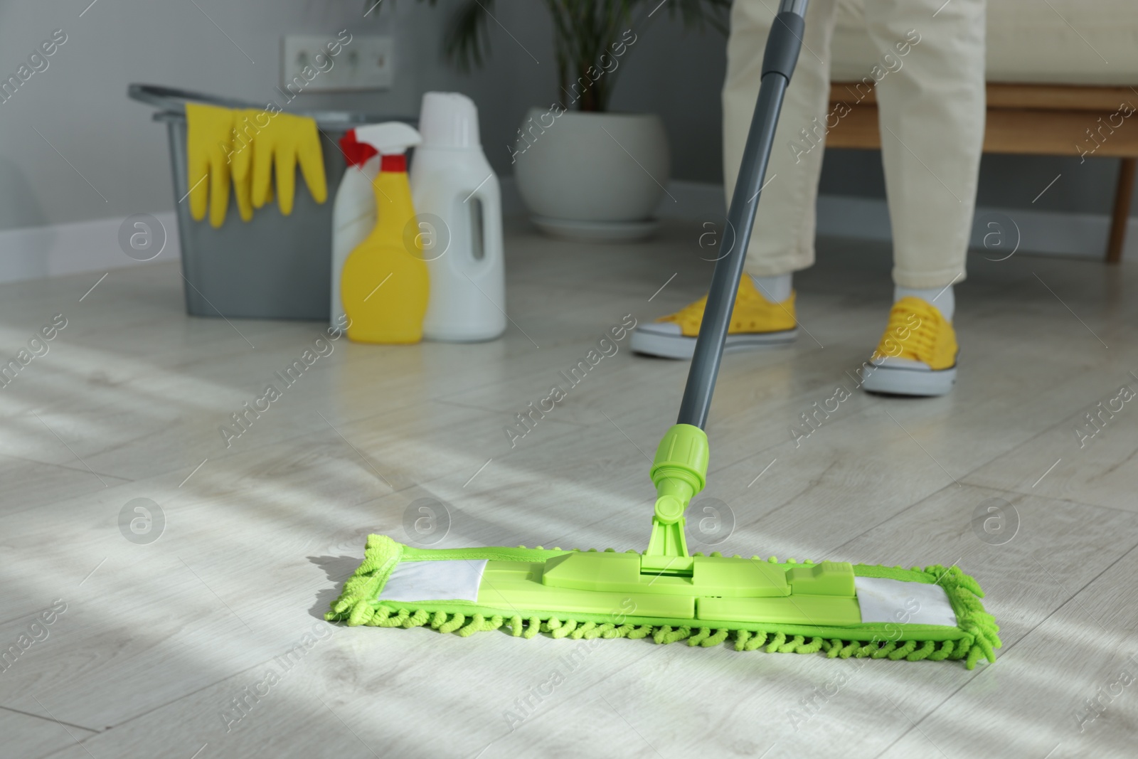 Photo of Woman cleaning floor with microfiber mop indoors, closeup