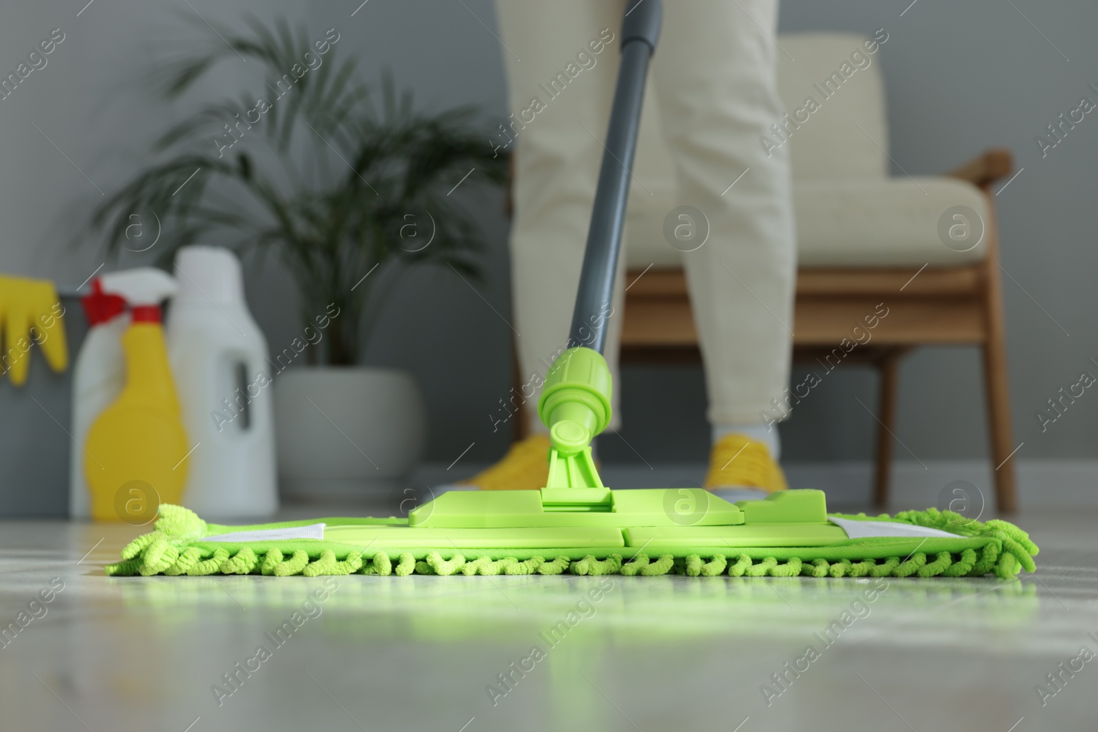 Photo of Woman cleaning floor with microfiber mop indoors, closeup