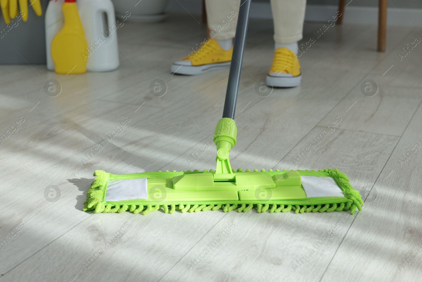 Photo of Woman cleaning floor with microfiber mop indoors, closeup