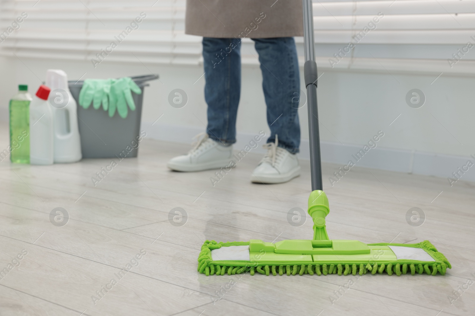 Photo of Woman cleaning floor with microfiber mop indoors, closeup