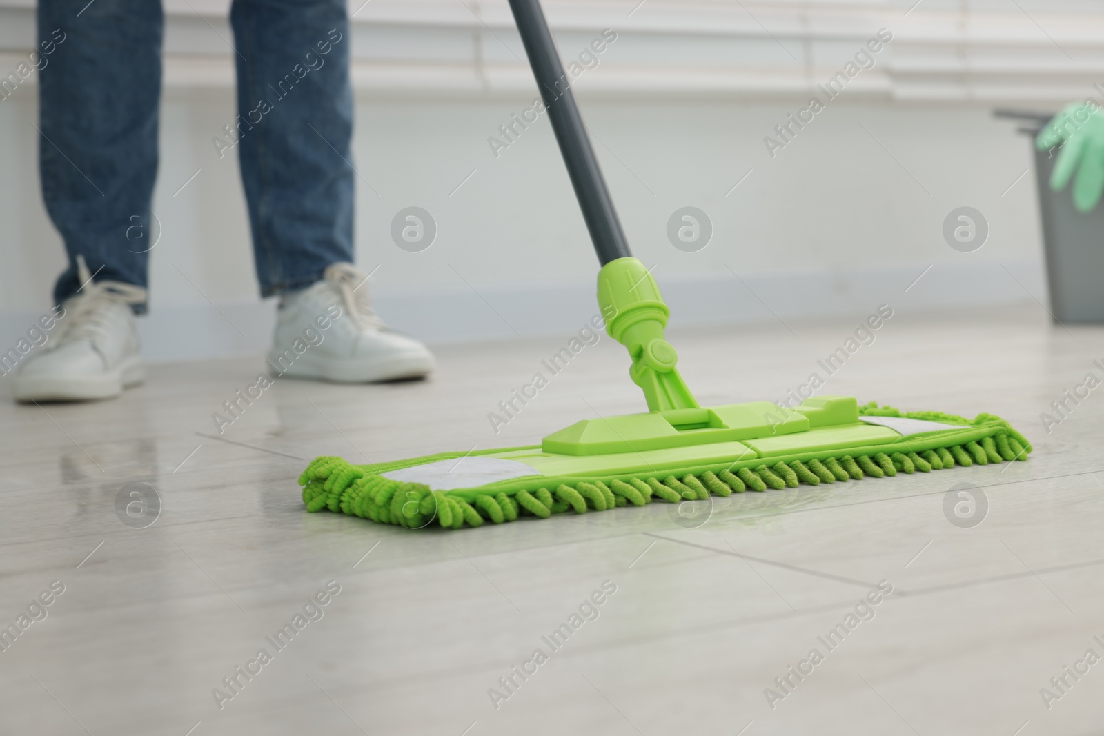 Photo of Woman cleaning floor with microfiber mop indoors, closeup