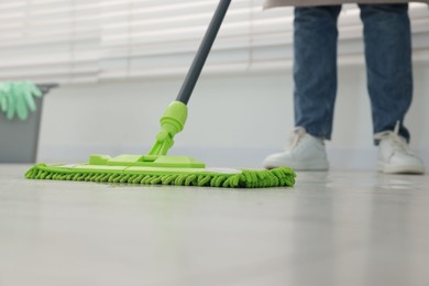 Photo of Woman cleaning floor with microfiber mop indoors, closeup