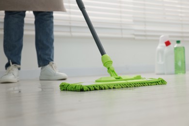 Photo of Woman cleaning floor with microfiber mop indoors, closeup