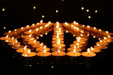 Photo of Many burning candles in darkness. Bokeh effect