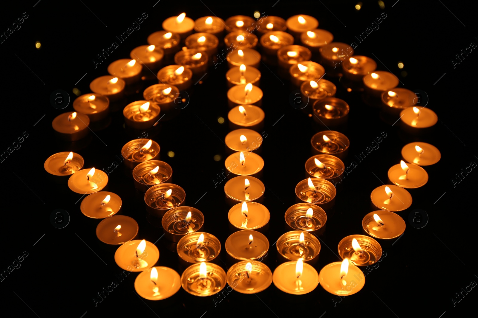 Photo of Group of burning church candles in darkness