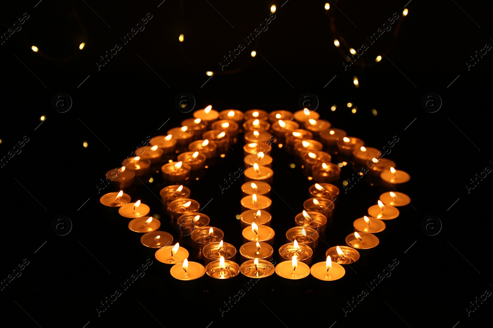 Photo of Group of burning church candles in darkness