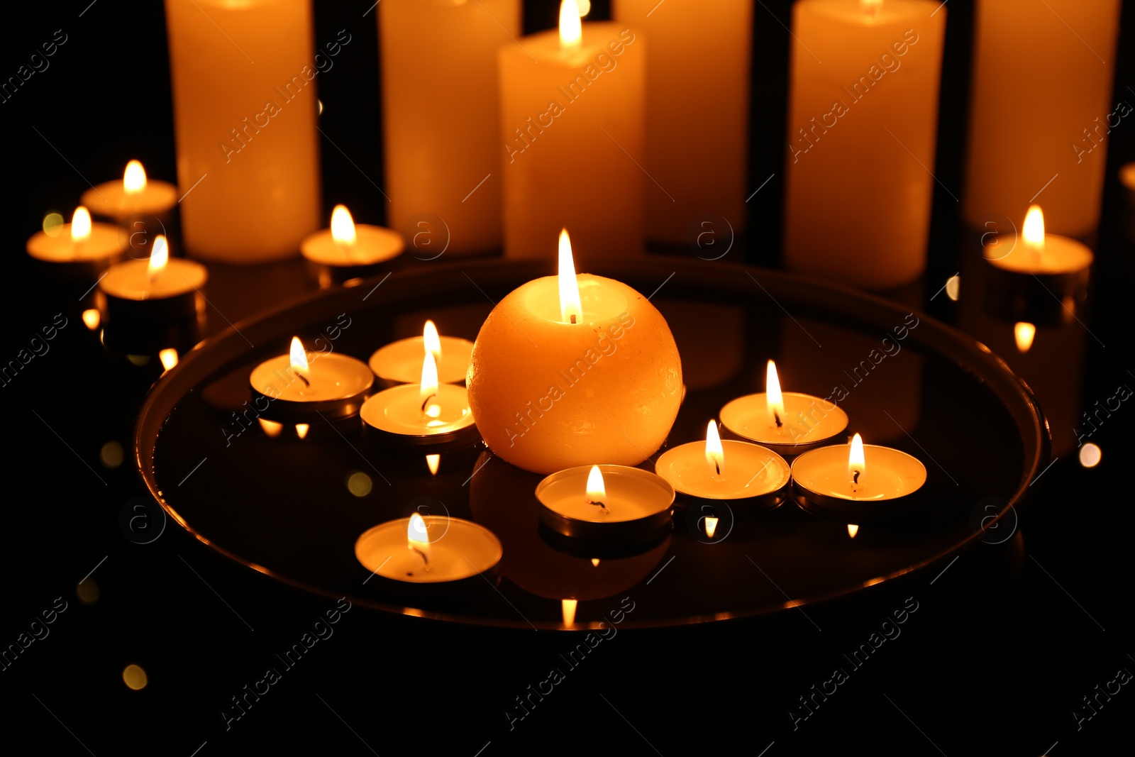 Photo of Group of burning candles on dark surface