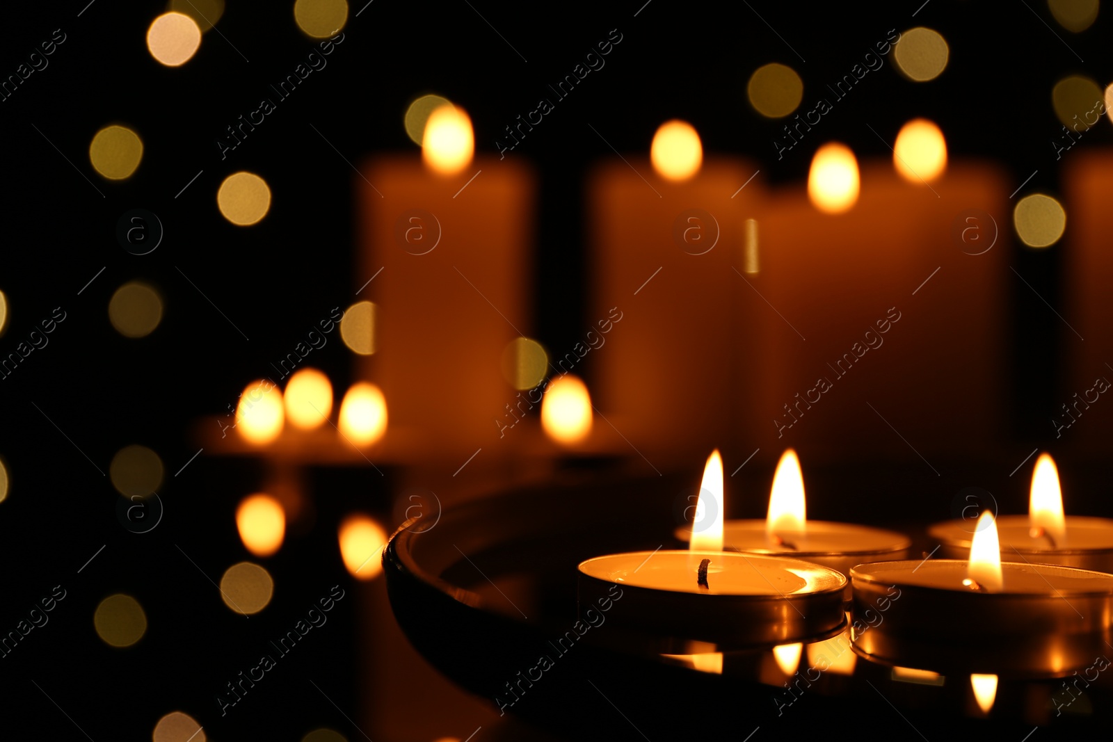 Photo of Many burning candles on dark surface, closeup. Space for text