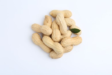 Pile of unpeeled peanuts on white background, top view