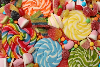 Photo of Different tasty candies as background, top view