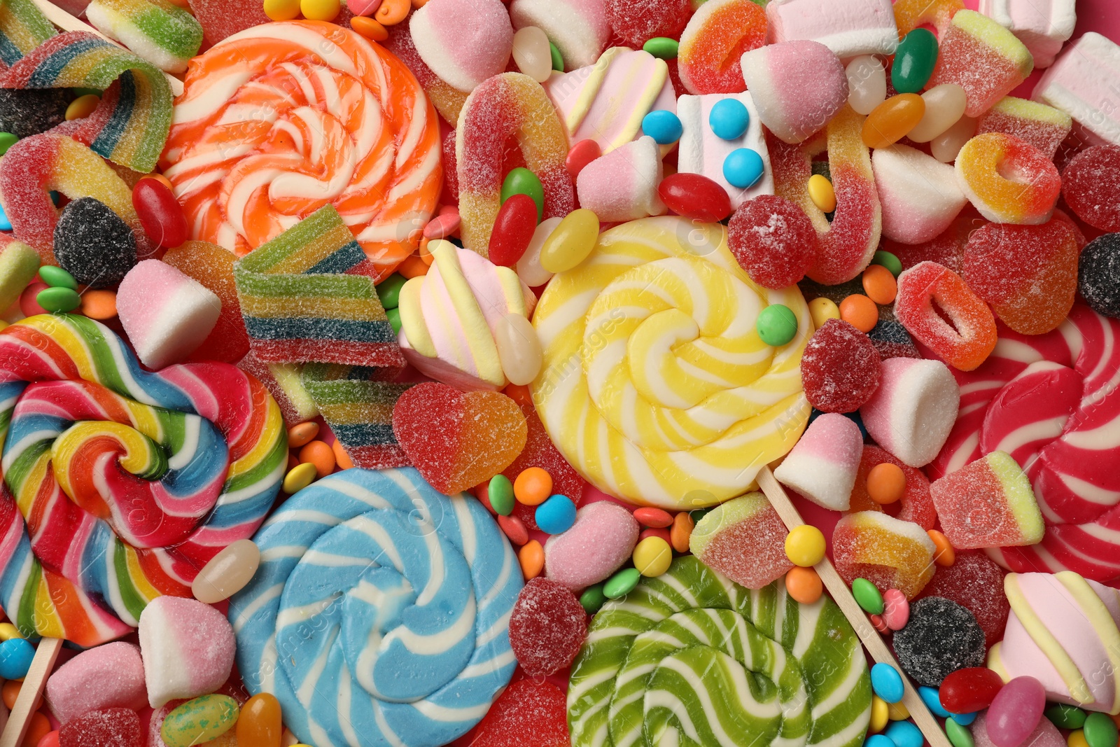 Photo of Different tasty candies as background, top view