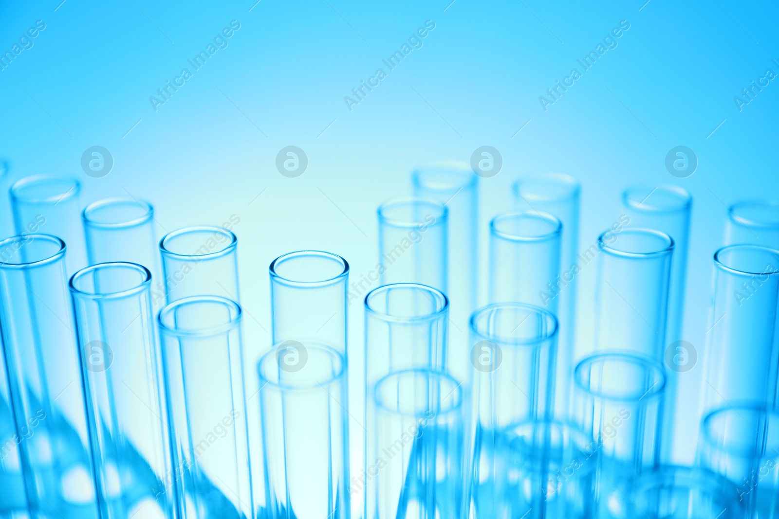 Photo of Test tubes on light blue background, closeup. Laboratory glassware