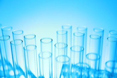 Photo of Test tubes on light blue background, closeup. Laboratory glassware