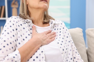 Heart attack. Senior woman suffering from pain in chest indoors, closeup