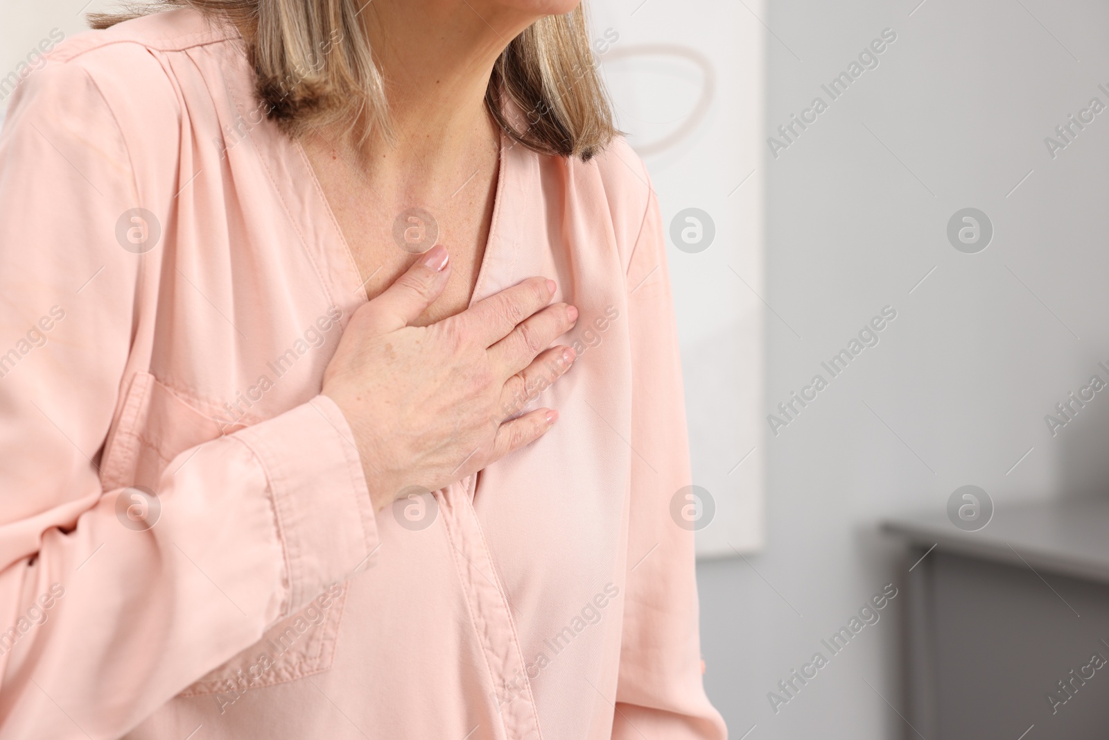 Photo of Heart attack. Senior woman suffering from pain in chest indoors, closeup. Space for text