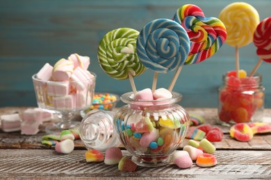 Photo of Many different tasty candies on wooden table