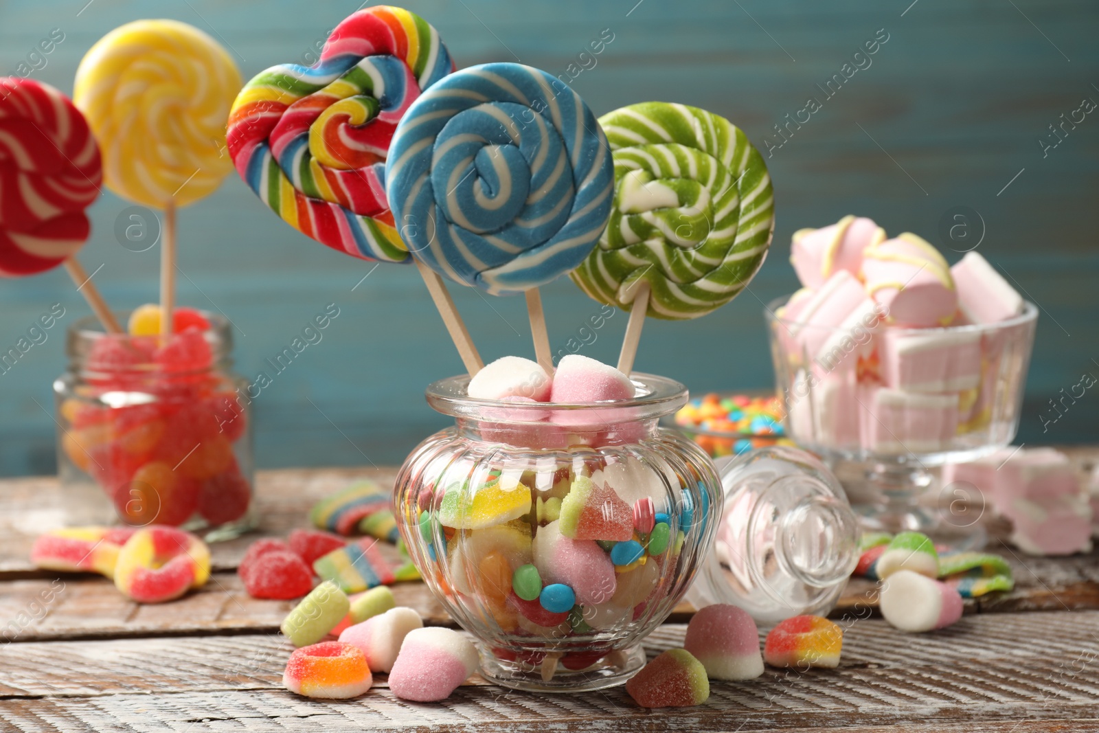 Photo of Many different tasty candies on wooden table