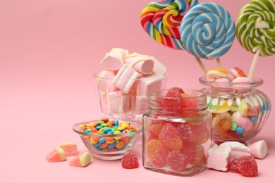 Photo of Different tasty candies on pink background, space for text