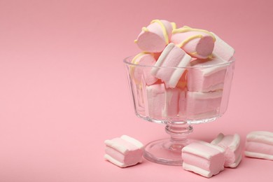 Photo of Tasty marshmallows in glass dessert bowl on pink background, closeup. Space for text