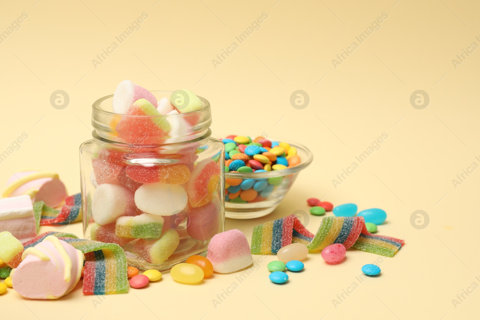 Photo of Different tasty candies on beige background. Space for text