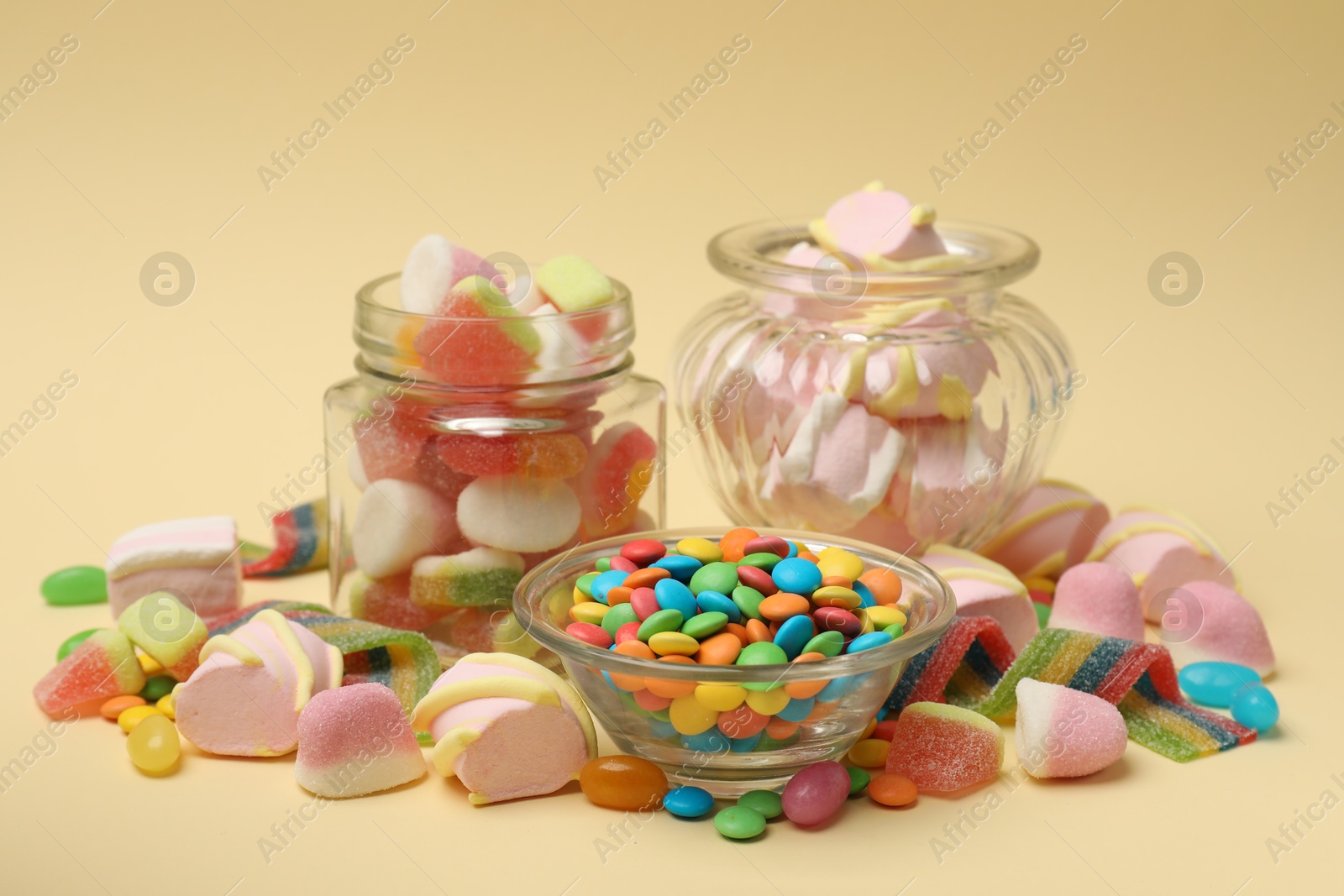 Photo of Many different tasty candies on beige background