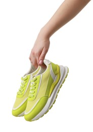 Photo of Woman with neon lime sneakers on white background, closeup