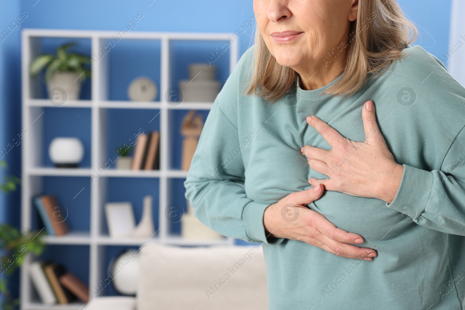 Photo of Heart attack. Senior woman suffering from pain in chest indoors, closeup. Space for text