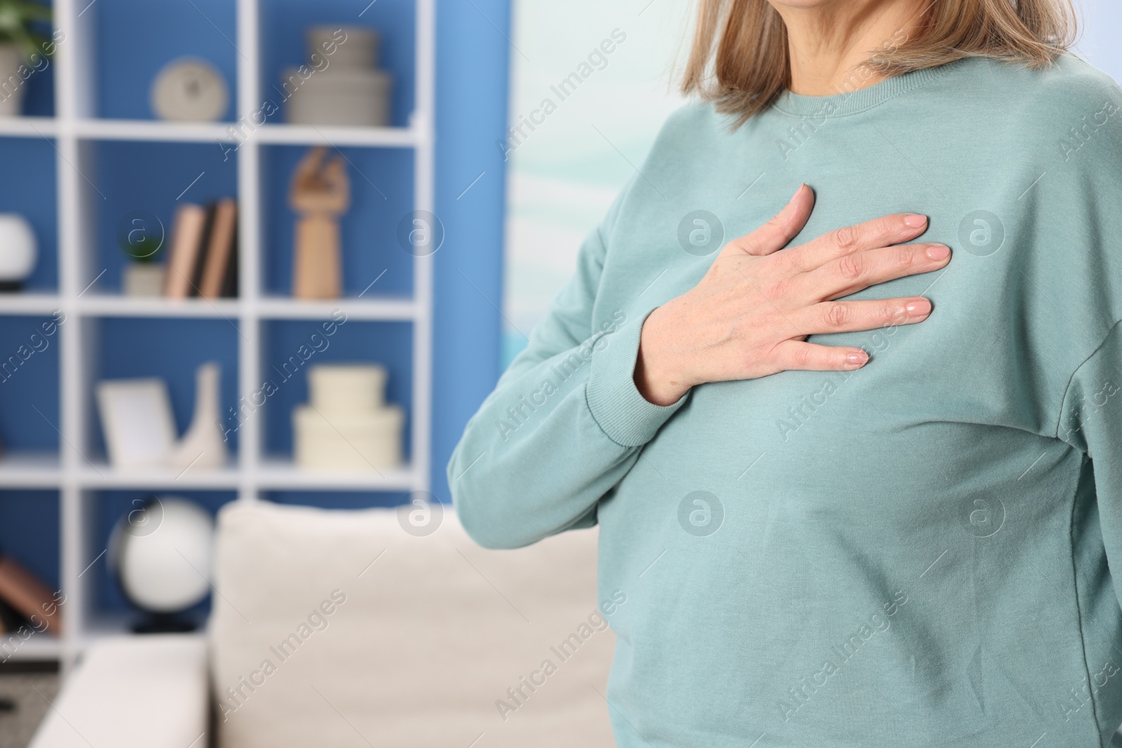 Photo of Heart attack. Senior woman suffering from pain in chest indoors, closeup. Space for text