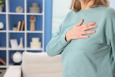 Photo of Heart attack. Senior woman suffering from pain in chest indoors, closeup. Space for text