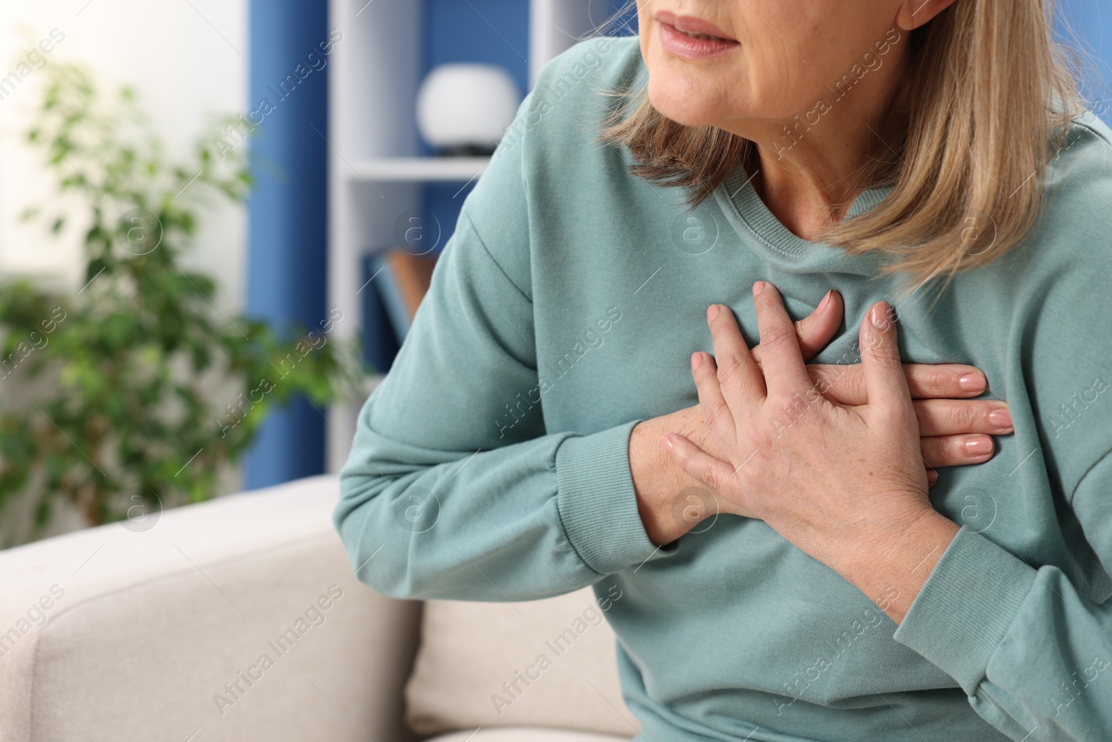 Photo of Heart attack. Senior woman suffering from pain in chest indoors, closeup. Space for text