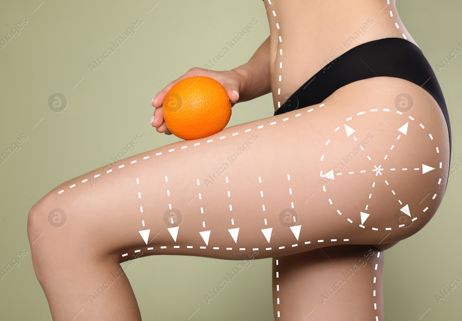 Image of Woman showing her beautiful body with smooth skin and holding orange on olive color background, closeup. Lines of anti-cellulite massage on skin