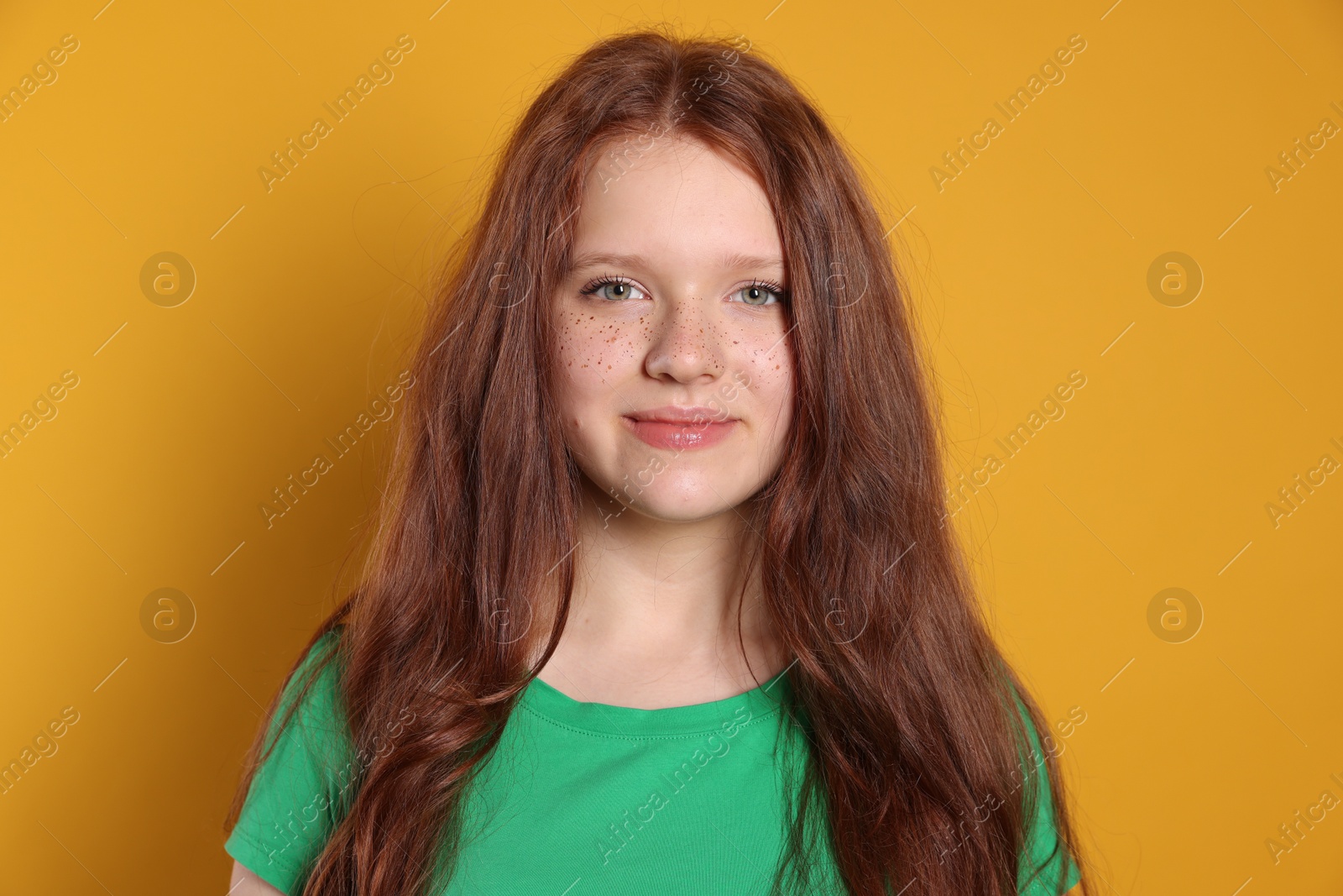 Photo of Beautiful teenage girl with freckles on orange background