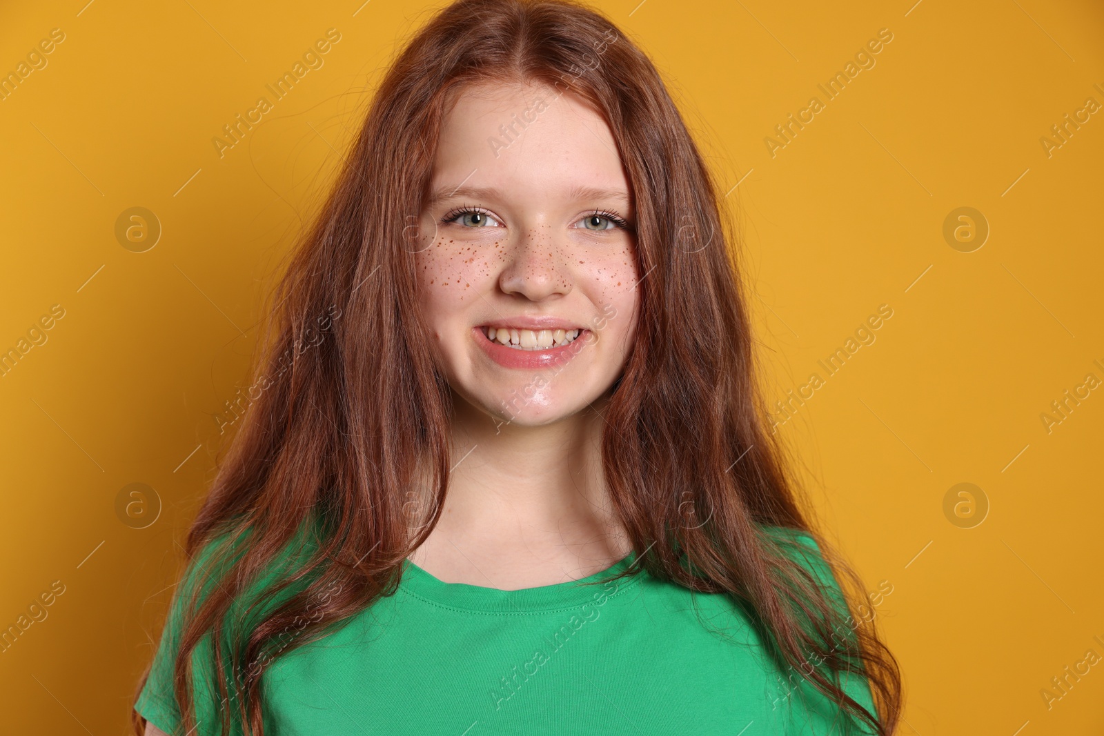 Photo of Beautiful teenage girl with freckles on orange background