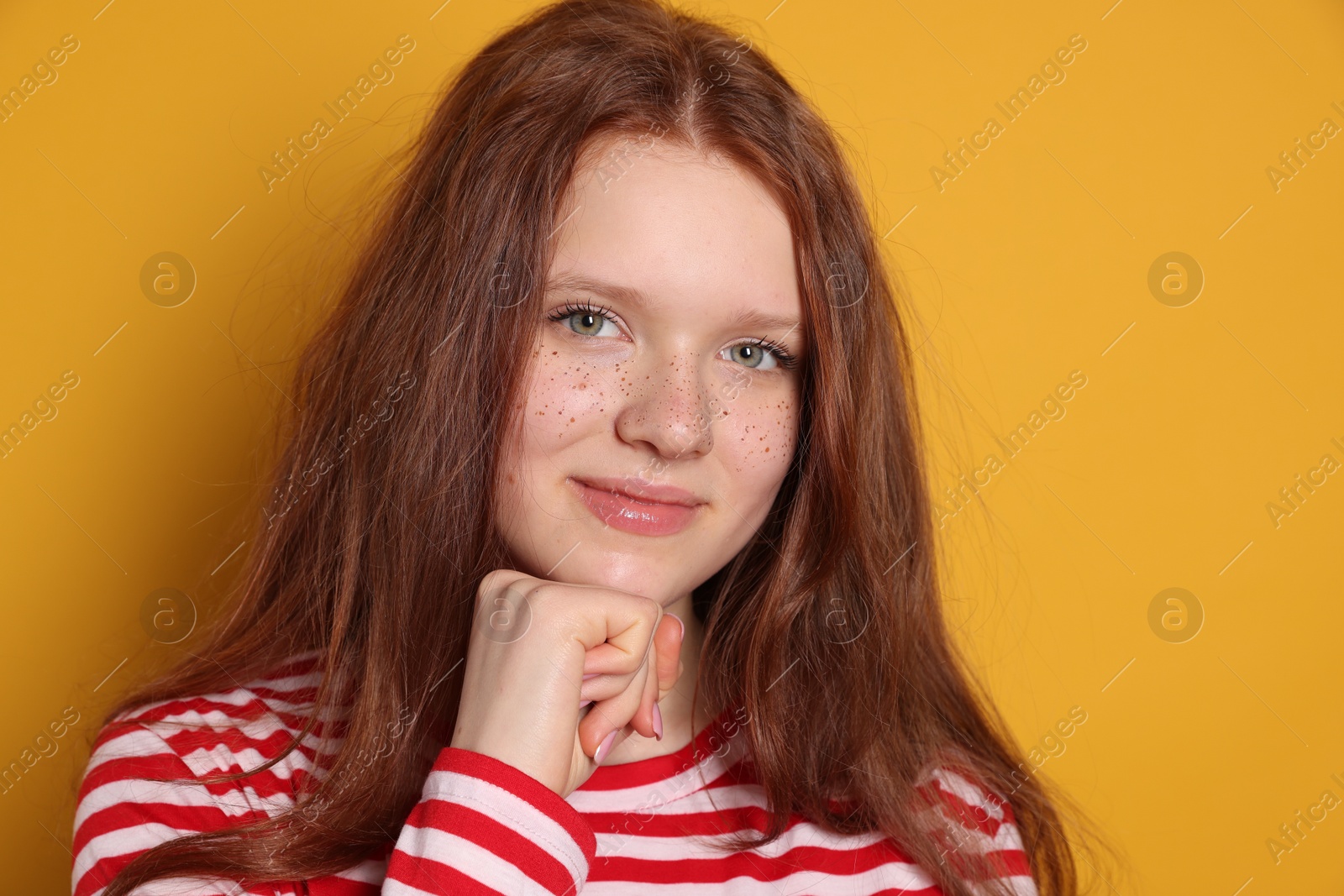 Photo of Beautiful teenage girl with freckles on orange background