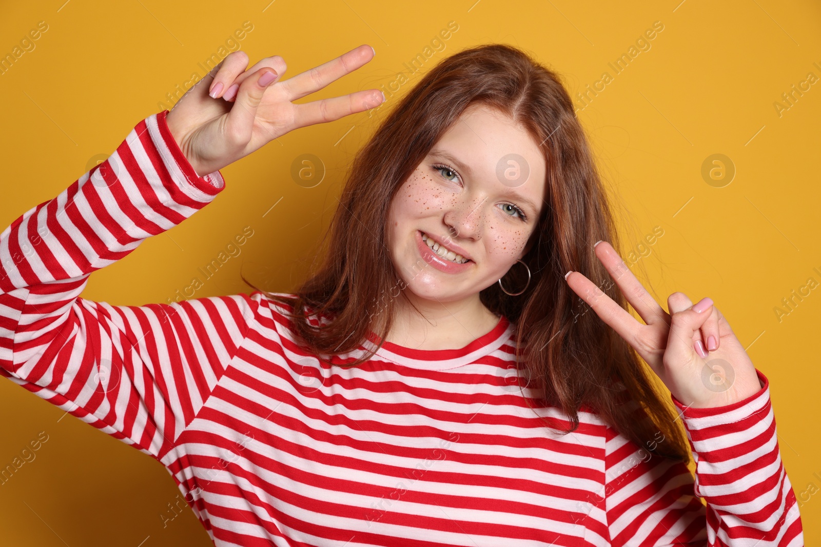 Photo of Beautiful teenage girl with freckles on orange background