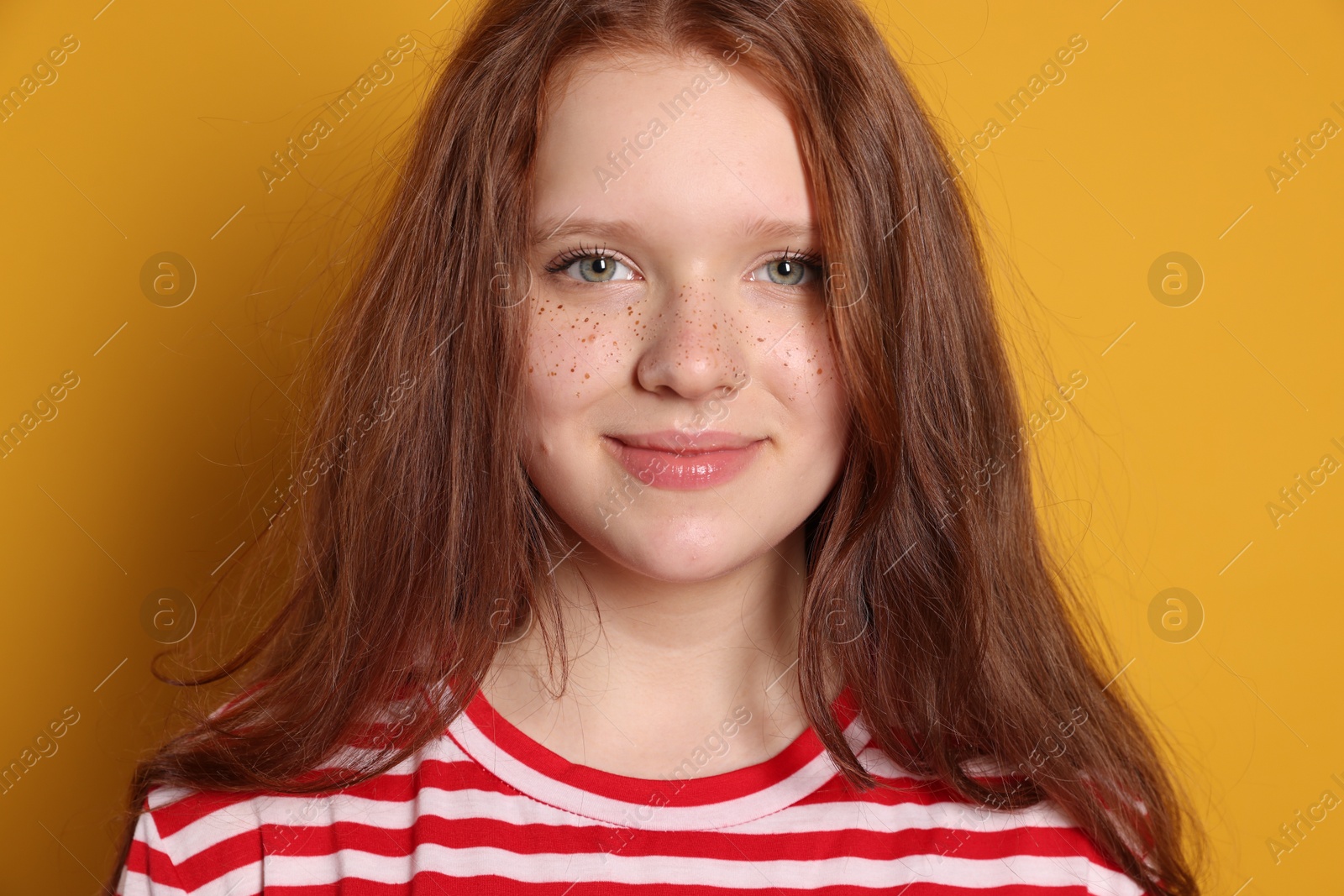 Photo of Beautiful teenage girl with freckles on orange background