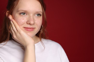 Photo of Beautiful teenage girl with freckles on red background, space for text