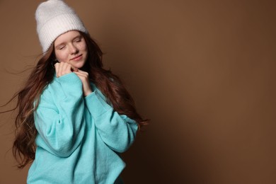 Photo of Beautiful teenage girl with freckles in hat on brown background, space for text